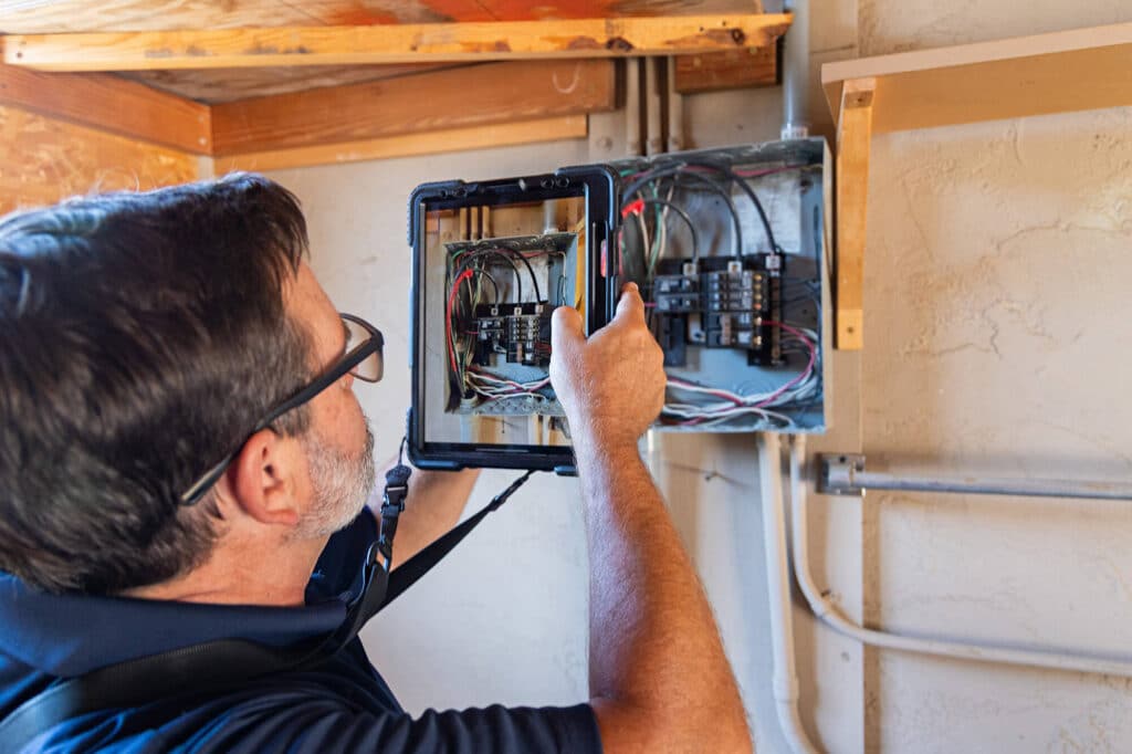 Electrician inspecting residential electrical breaker